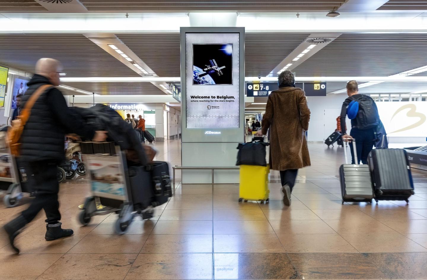 Campagne OOH créative avec un tunnel expérientiel lumineux et immersif pour la chancellerie du premier minsitre, visible à Brussels airport du 19 décembre 2025 au 16 janvier 2026