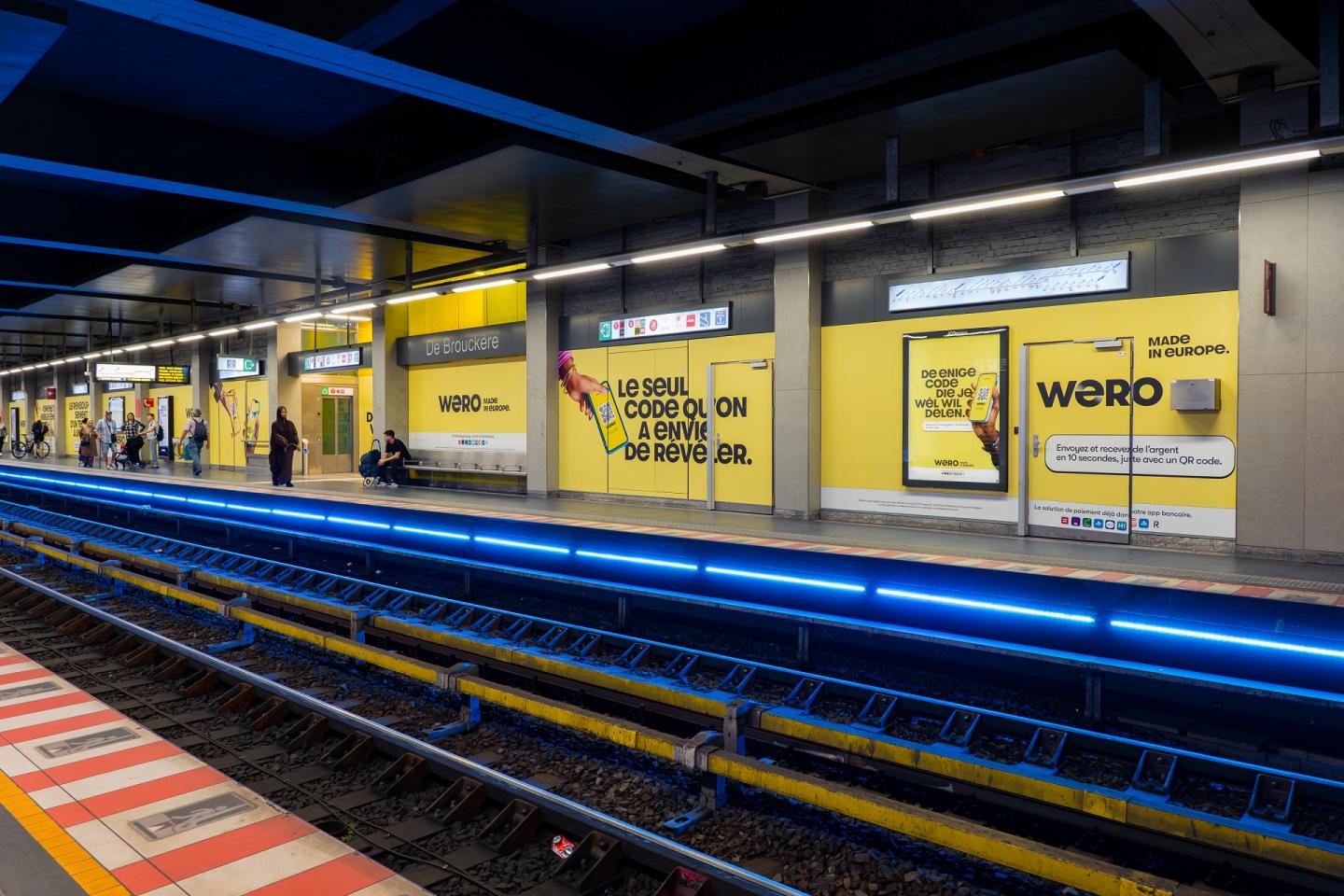 Een volledige station wrapping (OOH) van JCDecaux Belgium in het Brusselse station De Brouckère zet de betaaldienst Wero in de kijker.  De ruimte is volledig omgetoverd in felgeel met de logo's, visuals en tweetalige slogans van het merk langs de blauw verlichte sporen.