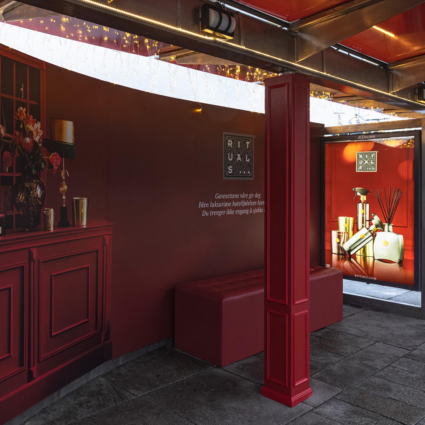 Winter Rituals campaign at tram stop with red panels and fairy lights in Oslo