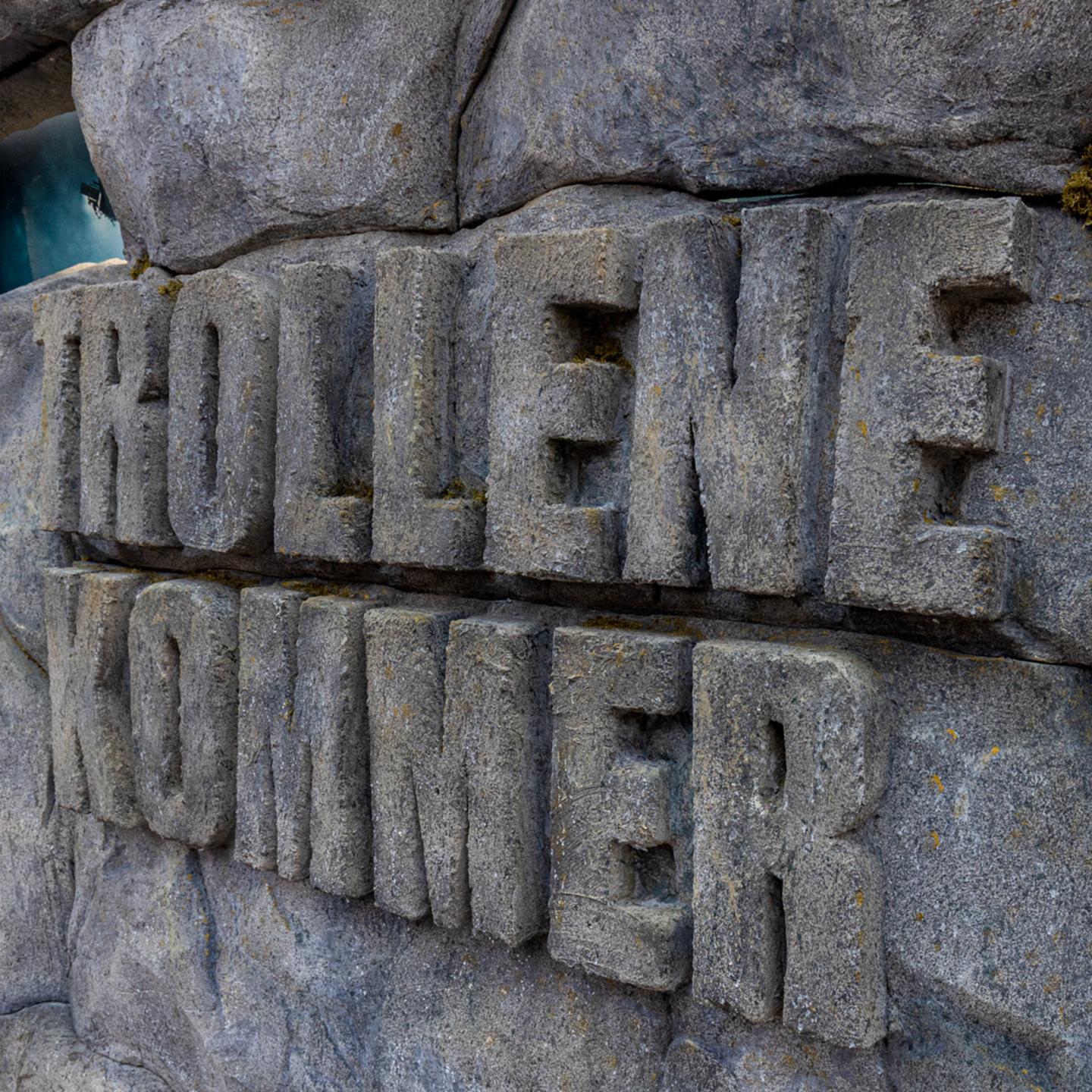 Stone-covered bus shelter gradually uncovering the official “Troll 2” film poster day after day