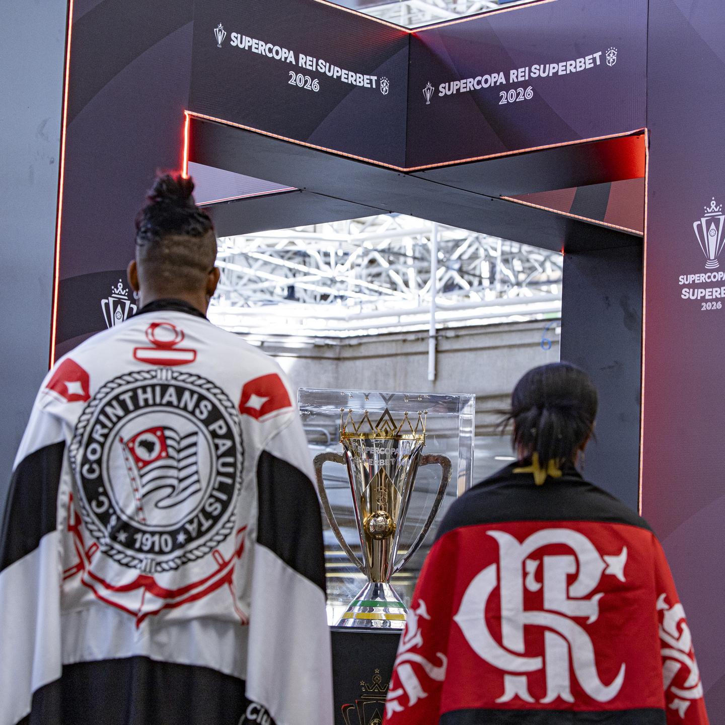 Passengers experiencing the Supercopa Rei trophy display inside Brasilia airport arrivals hall
