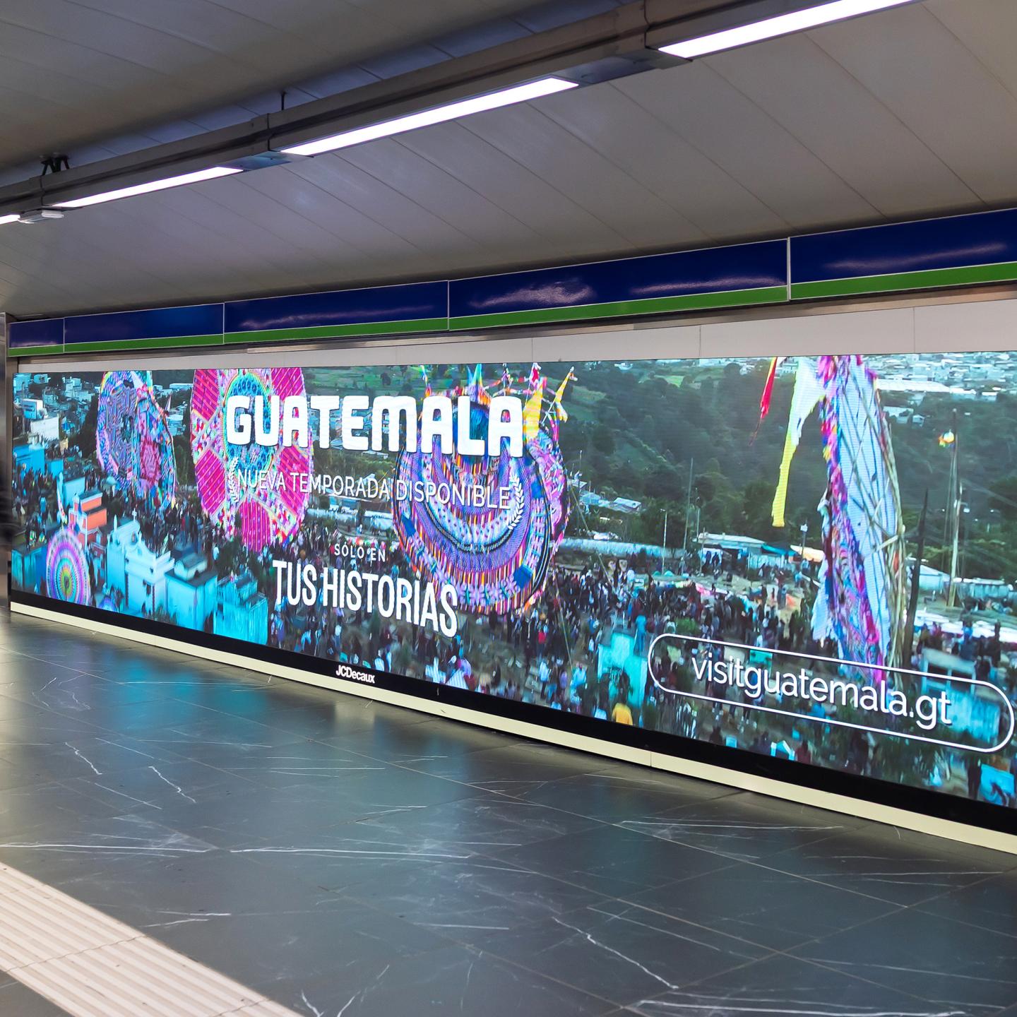 JCDecaux advertising surfaces in Madrid metro promoting Guatemala tourism with images of majestic landmarks and outdoor adventures.