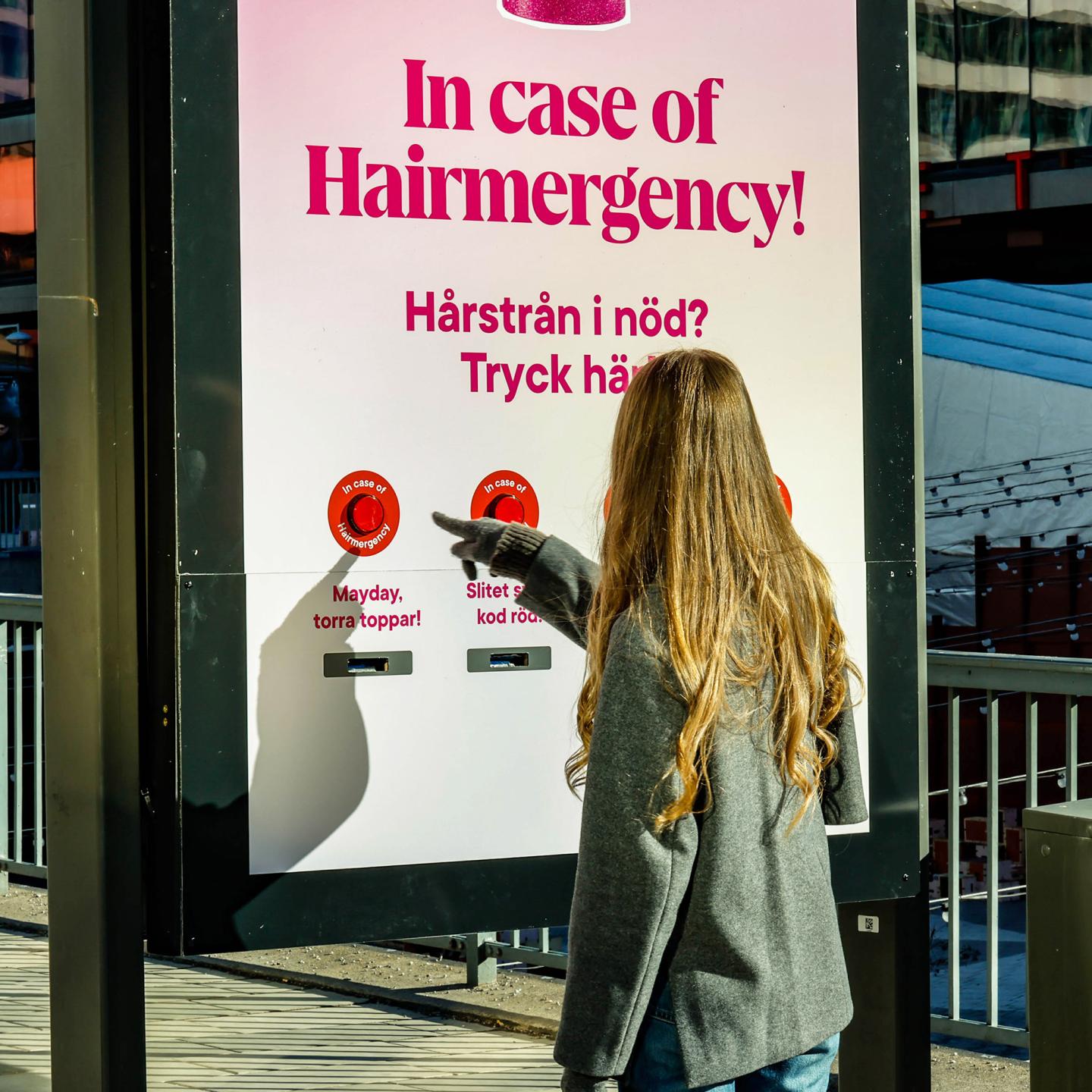 JCDecaux Sweden digital panel showing Lyko Hairmergency campaign inviting passers-by to press a button for beauty advice