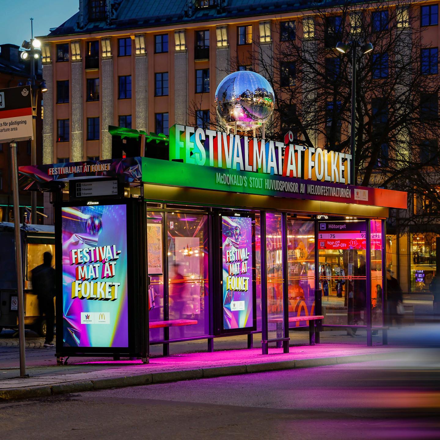 Disco ball and colourful neon lights turning a Stockholm bus shelter into a festive space for McDonald’s and Melodifestivalen