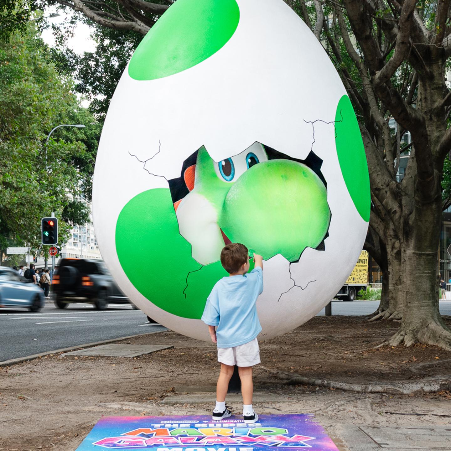 A JCDecaux out-of-home creative installation in Sydney featuring a massive Yoshi egg sculpture on a sidewalk to promote The Super Mario Galaxy Movie