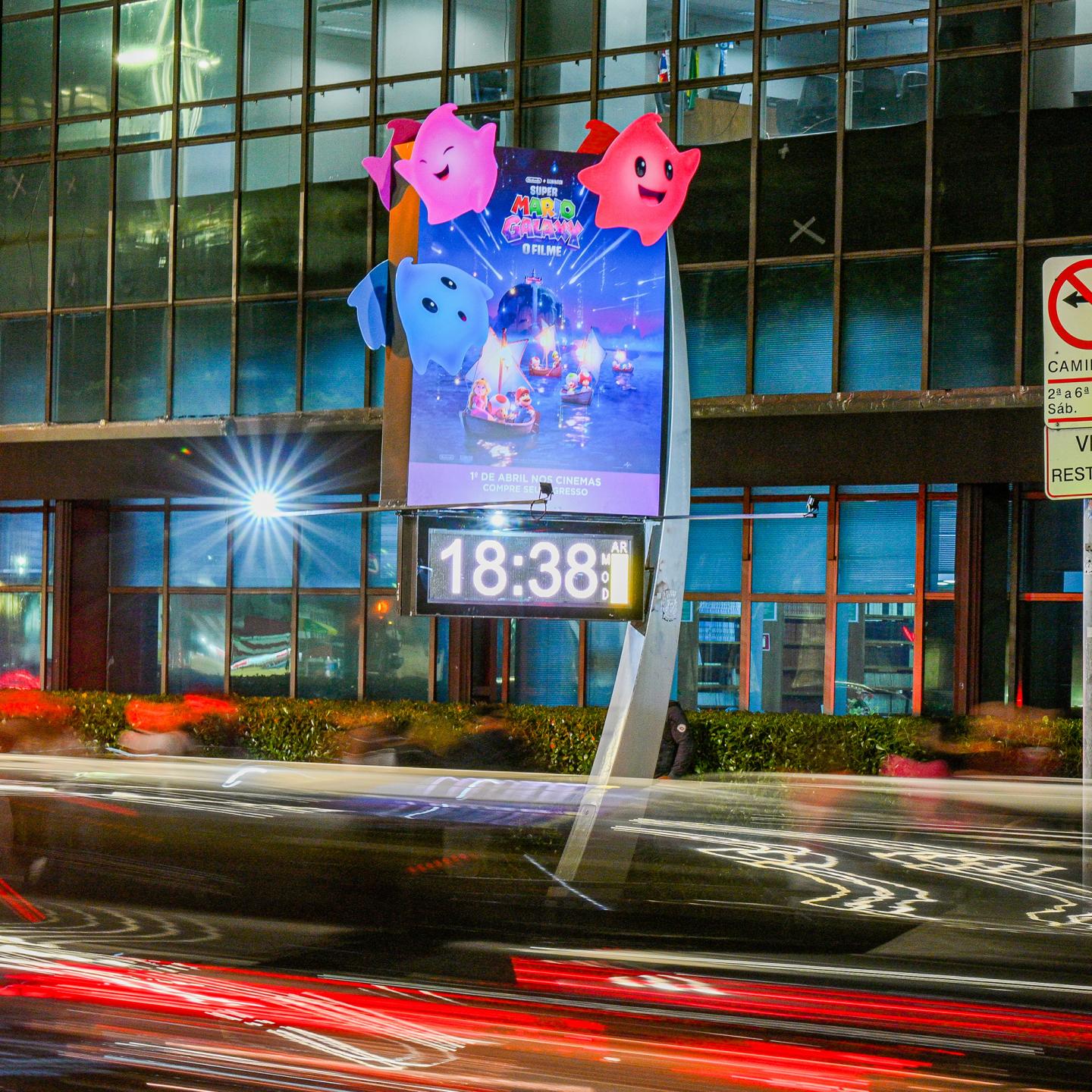 A JCDecaux digital street furniture display in Brazil at night, featuring 3D glowing Luma characters attached to the top of a bright advertising panel
