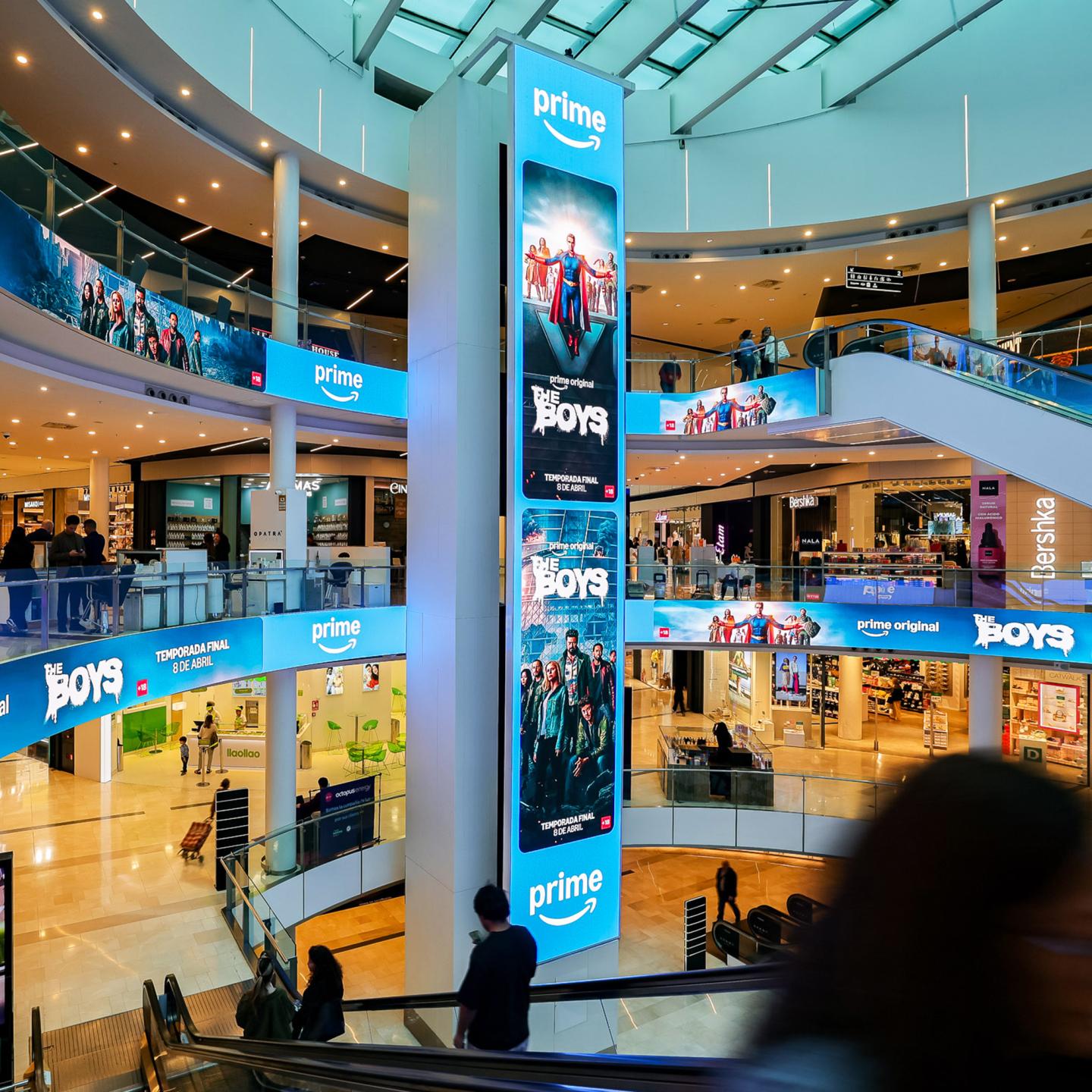 Shoppers walking past large-scale Prime Video digital adverts for The Boys series in the main aisles