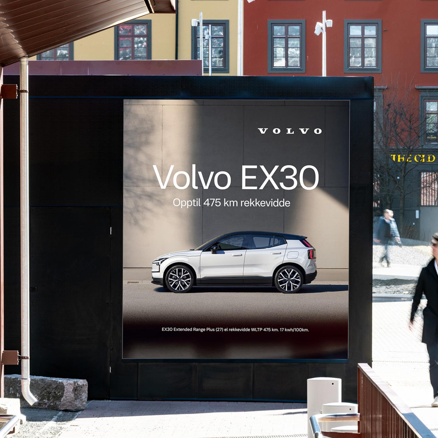 Crowds of commuters at Majorstuen station passing by a massive Volvo EX30 outdoor advertisement
