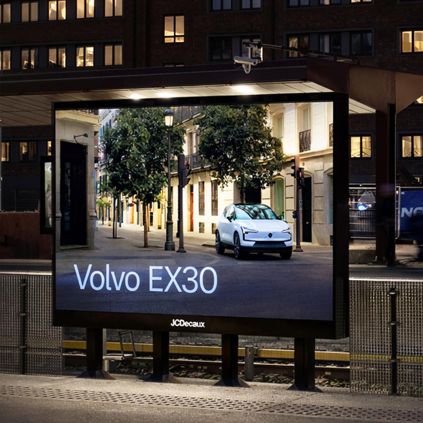 Side view of a Volvo EX30 advertisement on a JCDecaux premium outdoor display in a busy transit hub.