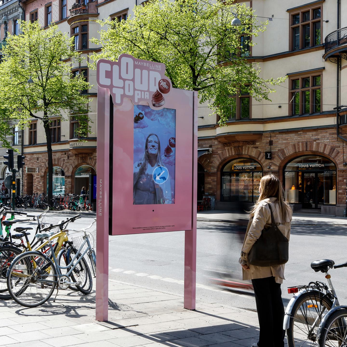 Close view of a JCDecaux digital panel used as an augmented reality mirror, allowing pedestrians to virtually try Maybelline Cloudtopia Lip and Cheek Mousse shades.