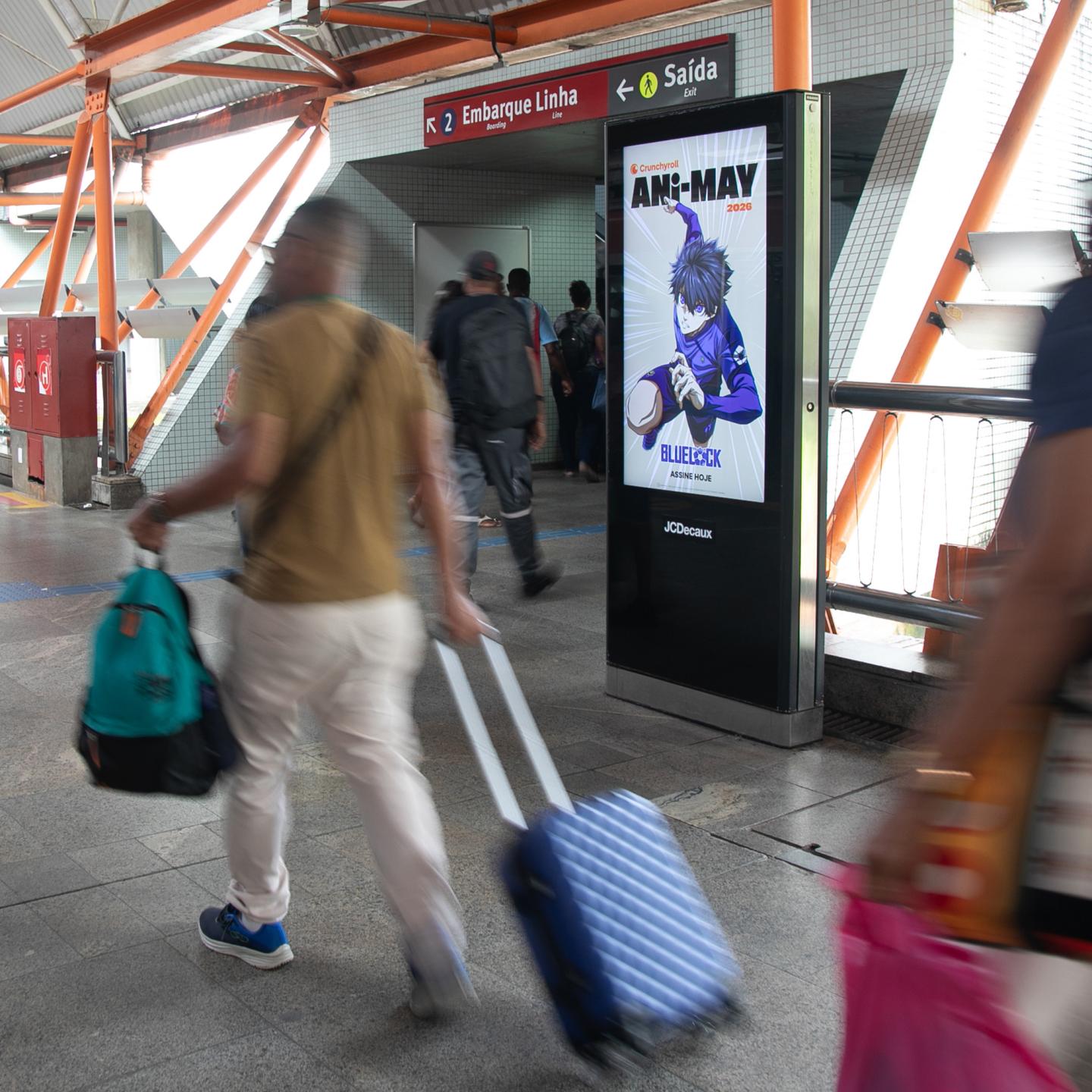 JCDecaux advertising panels in a busy Brazilian transport hub displaying colourful Crunchyroll anime artwork.
