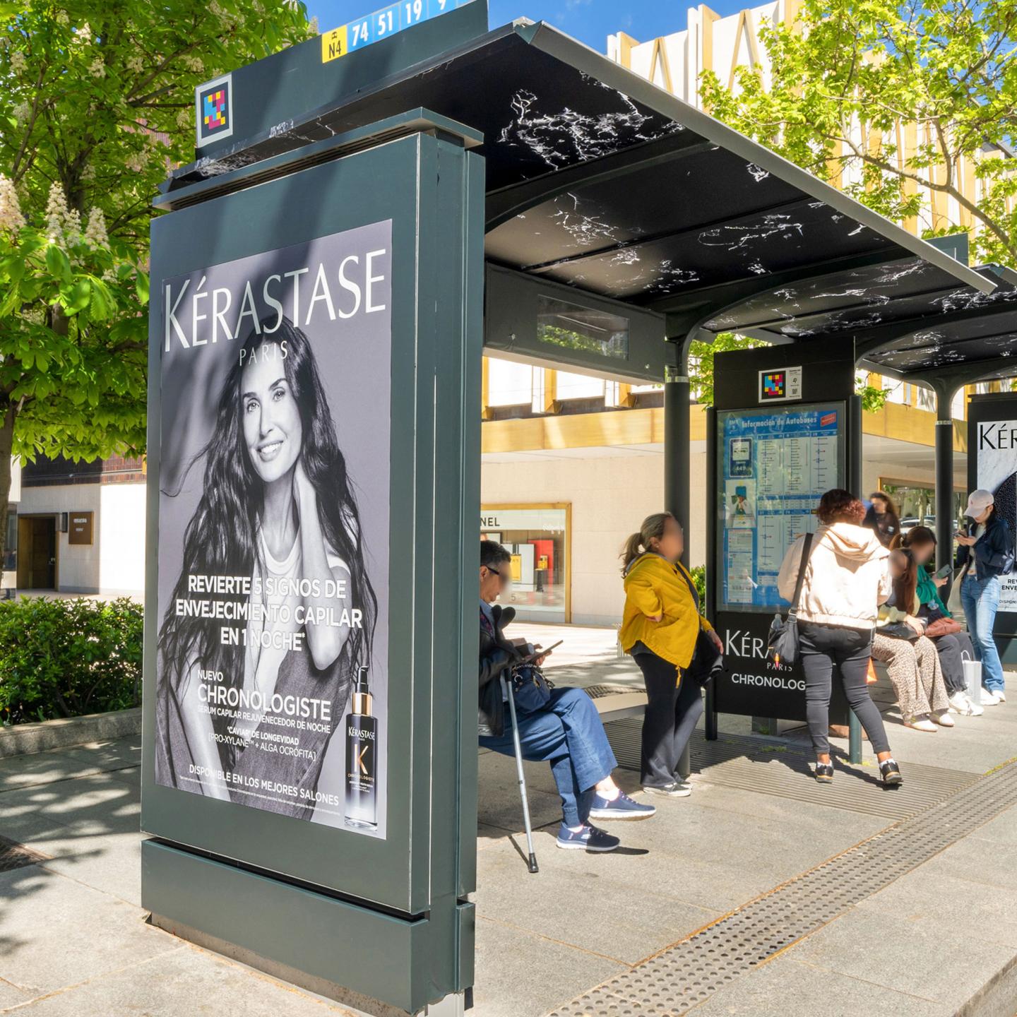 Close‑up of a JCDecaux bus shelter featuring a marble‑effect wrap and deep black façade for a Kérastase haircare campaign.