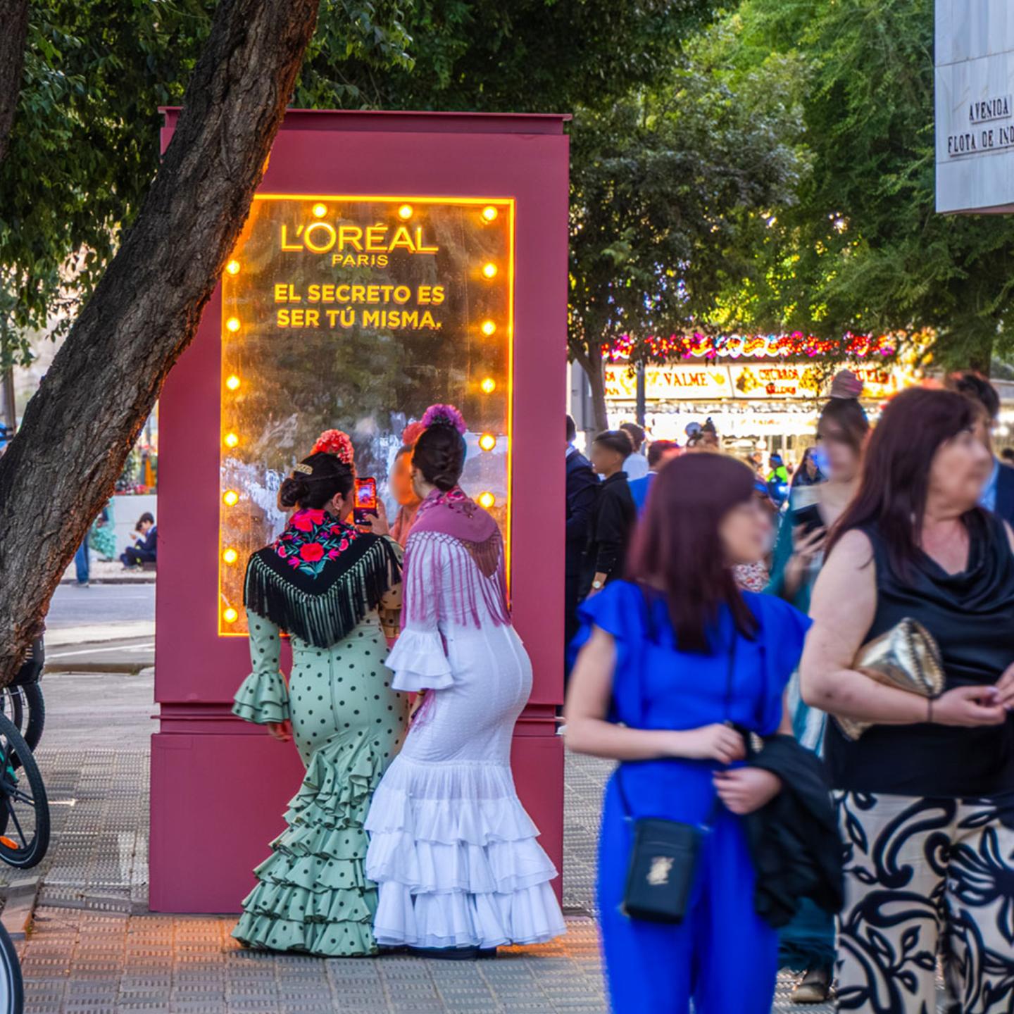 JCDecaux street furniture transformed into a vanity mirror, reflecting the Feria de Abril crowd and L’Oréal Paris branding.