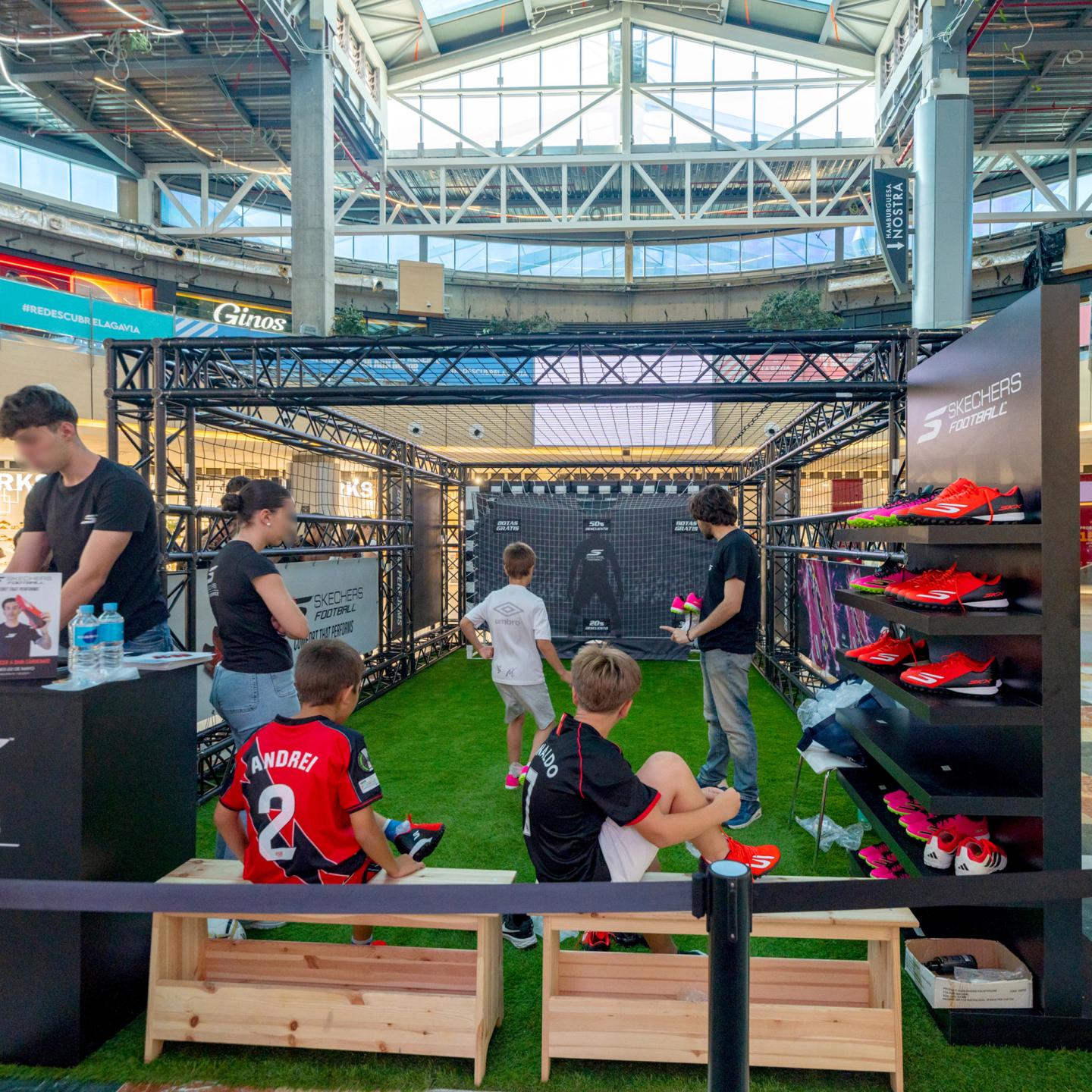 Children playing on the Skechers penalty shoot‑out pitch while staff supervise the activation
