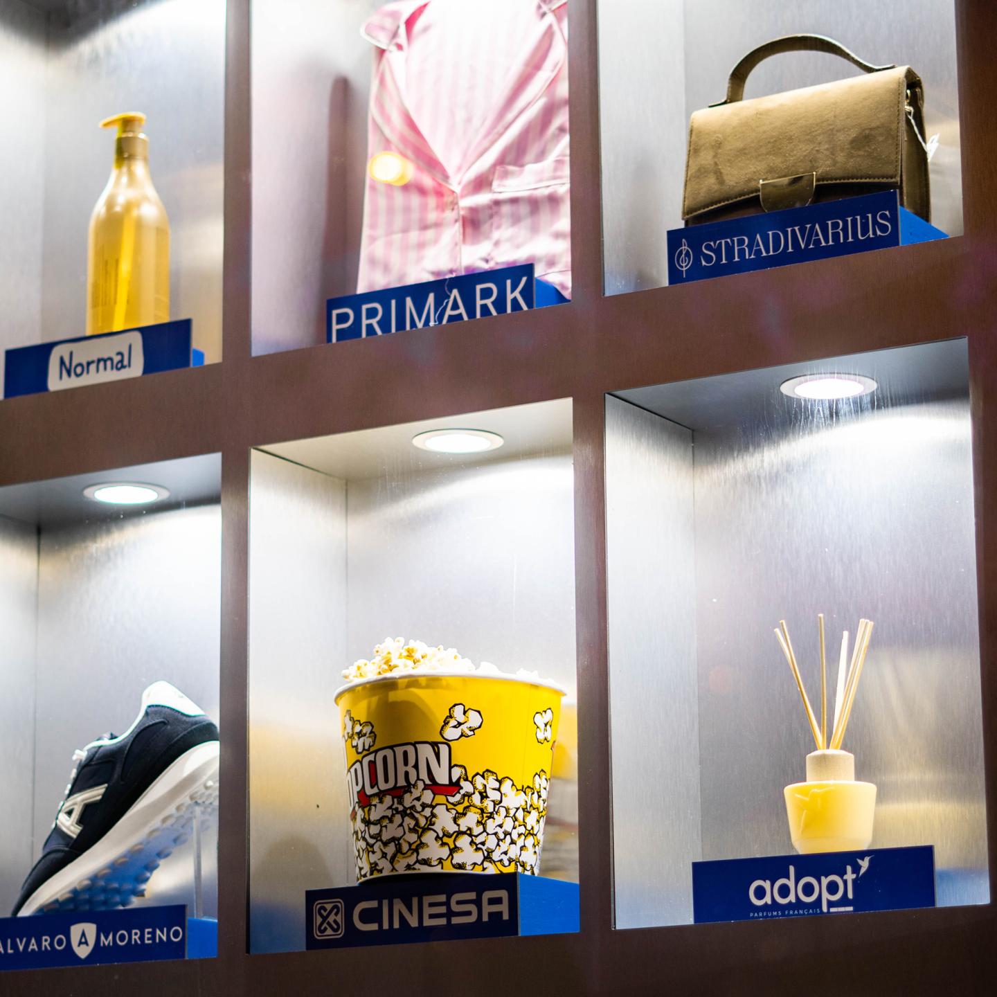 Close-up of a JCDecaux mupi in Zaragoza, with illuminated compartments displaying products from GranCasa brands such as Primark, Stradivarius and Cinesa.