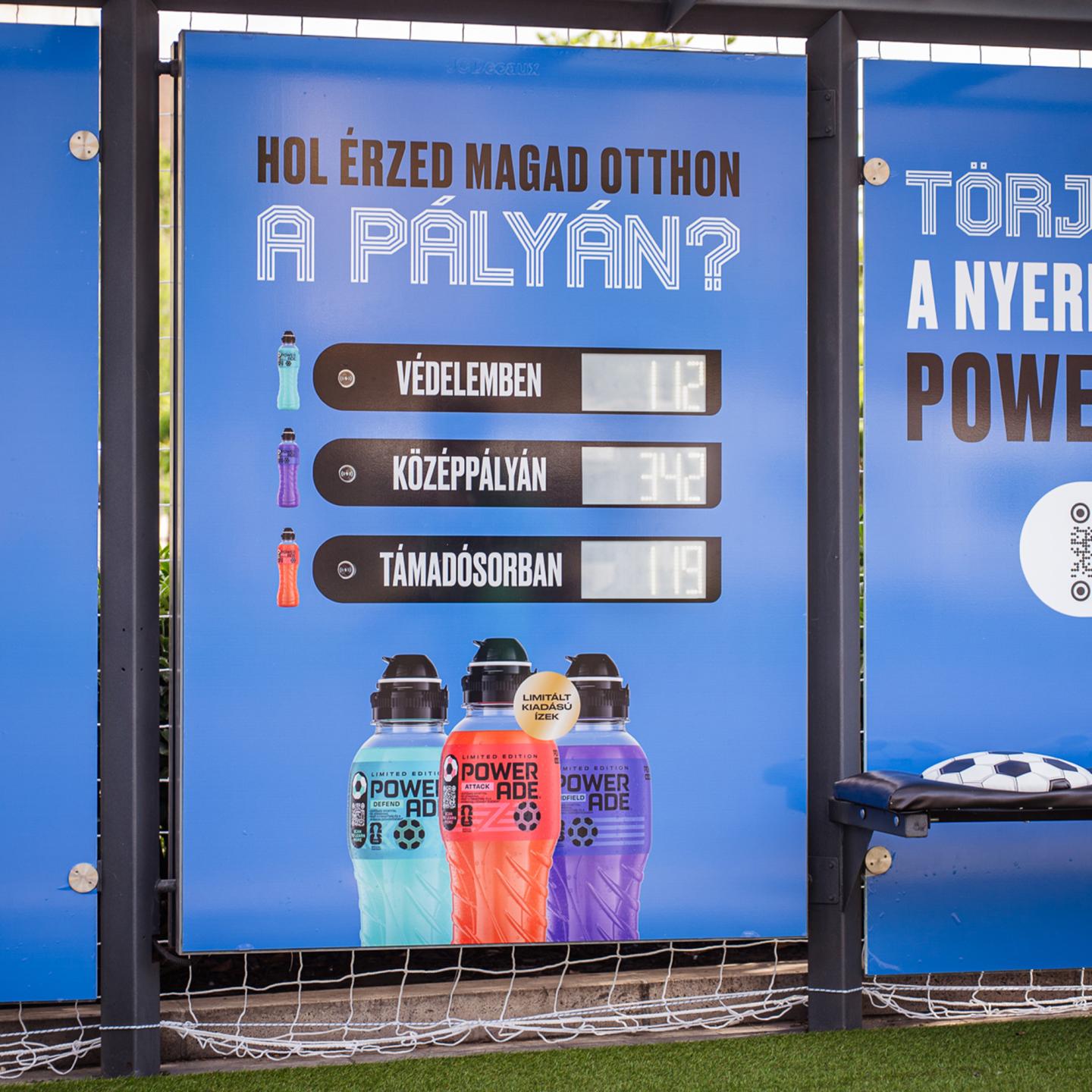 Detail of the JCDecaux bench at the Powerade bus stop, featuring round cushions designed like classic black‑and‑white footballs on artificial grass.