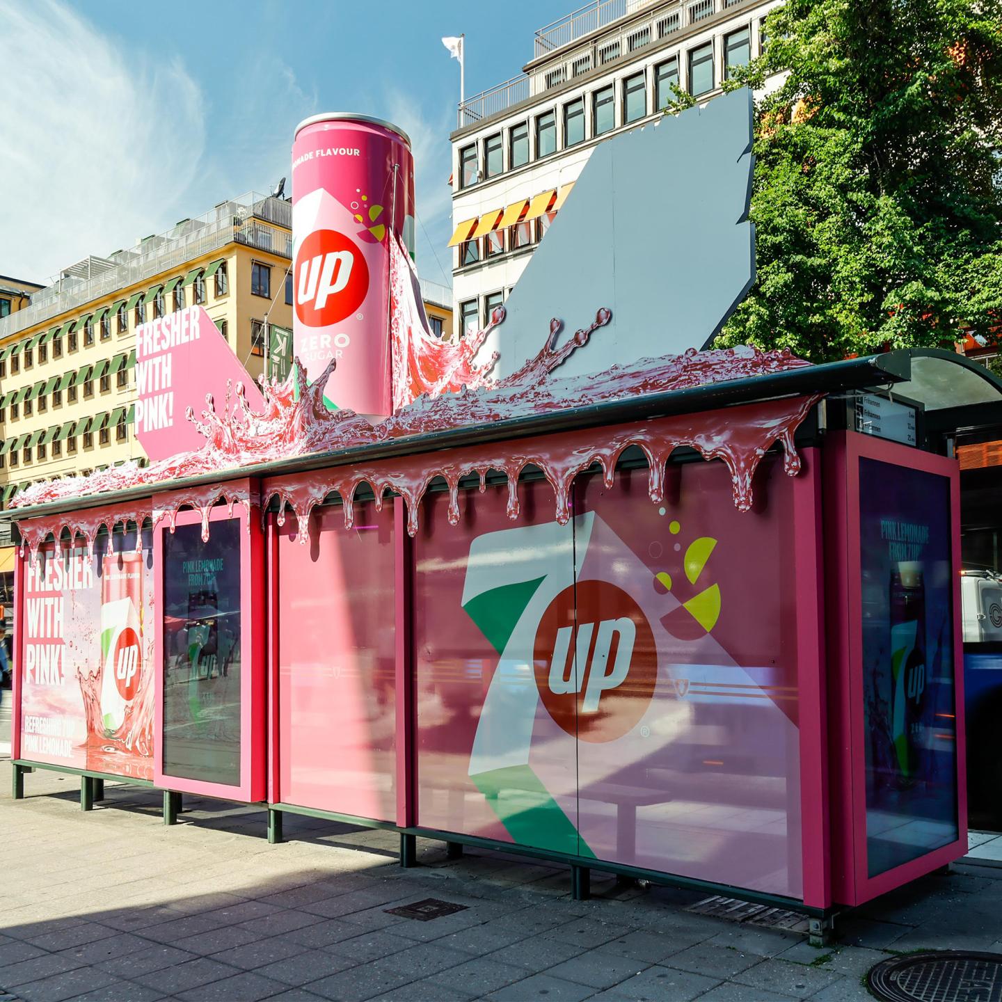 Pink JCDecaux bus shelter campaign for 7Up with striking visuals and oversized can display