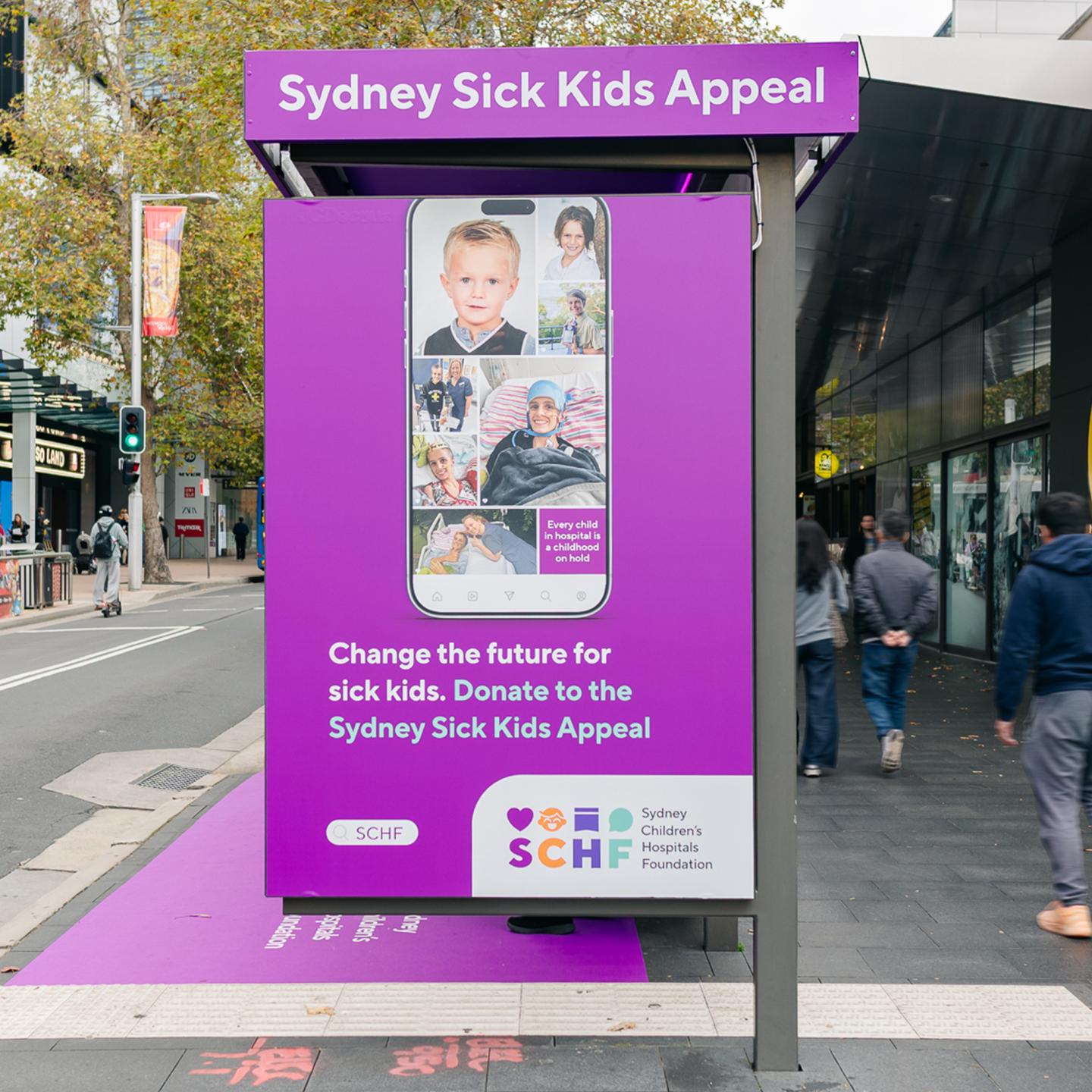 Detail of metallic donation box and Sydney Children’s Hospitals Foundation logo on purple pavement.