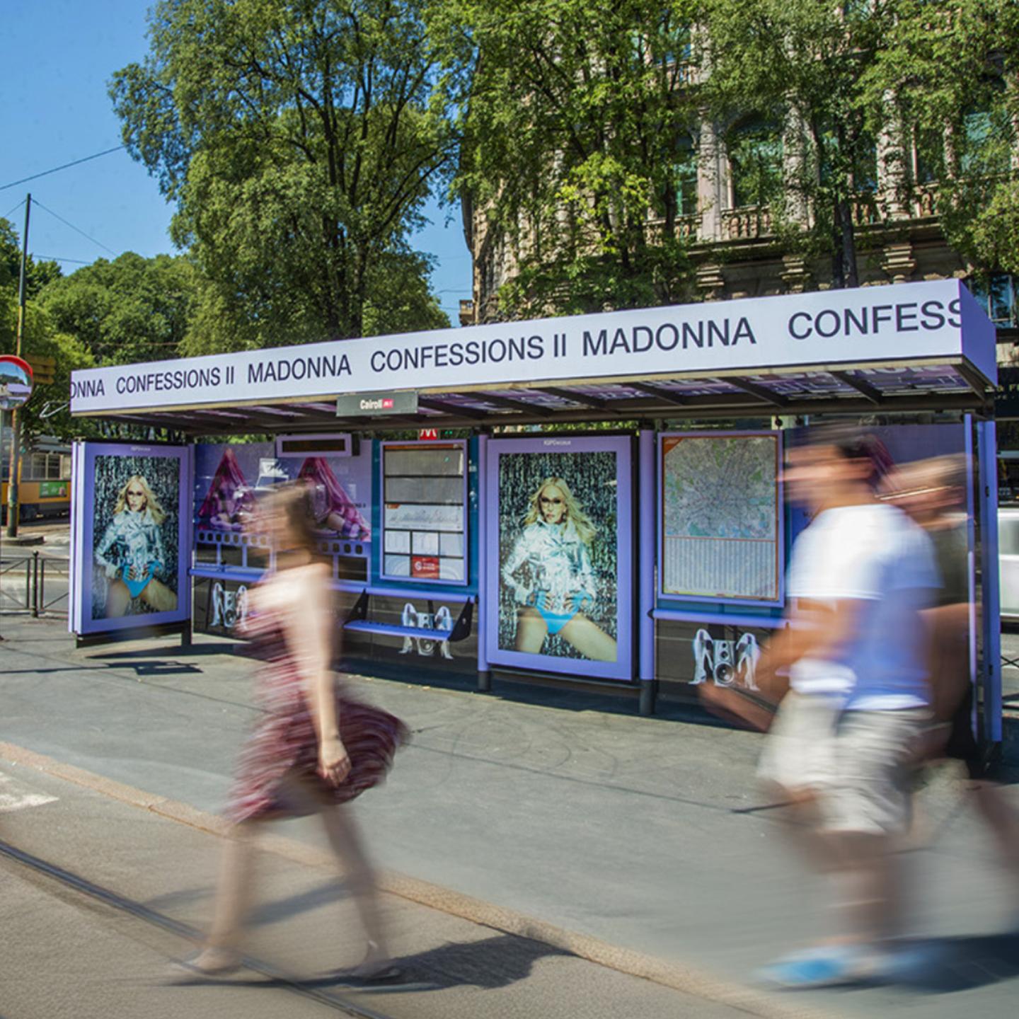 Wide view of the fully wrapped purple IGPDecaux bus shelter at Cairoli station during the Warner Music campaign for Madonna