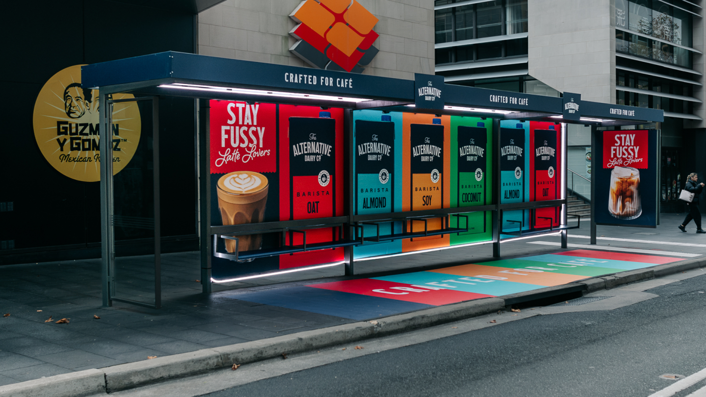 Bespoke JCDecaux bus shelter in Sydney featuring neon lighting and vibrant artwork for The Alternative Dairy Co. plant-based milk campaign.
