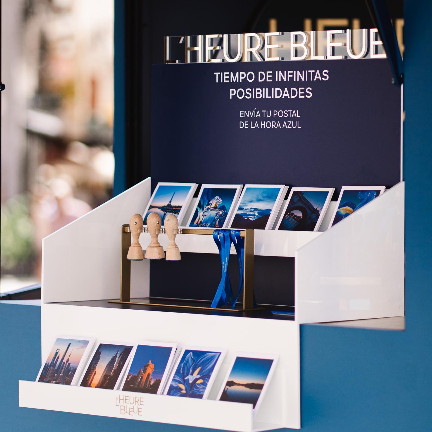 Detail of L’Heure Bleue product line with the blue perfume bottle, heart-shaped soap and scented mists arranged on a mirrored tray.