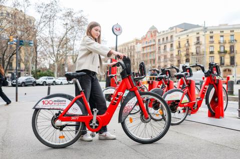 Una mujer se prepara para montar en una bicicleta de Bicing.