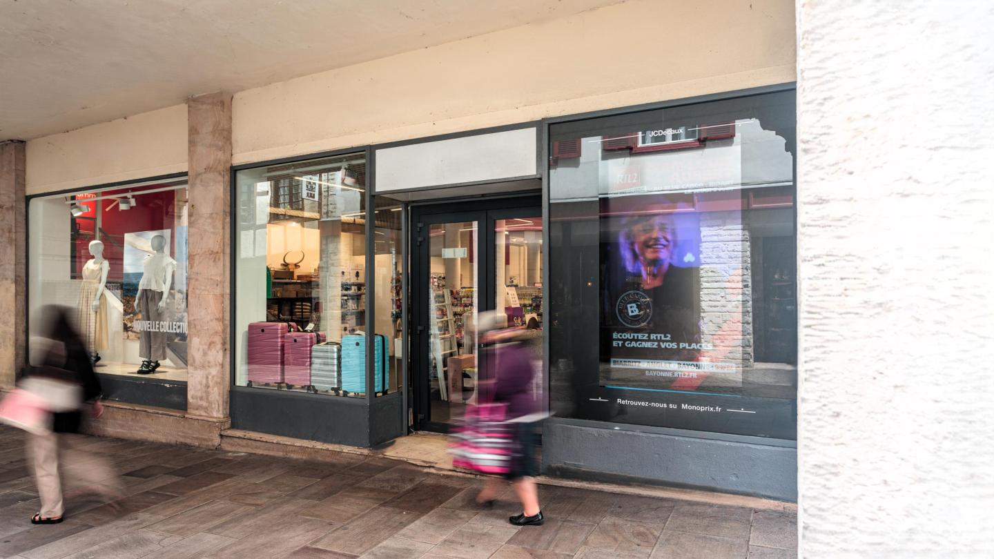 Un écran JCDecaux sur la vitrine d'un Monoprix promeut RTL2 à Bayonne