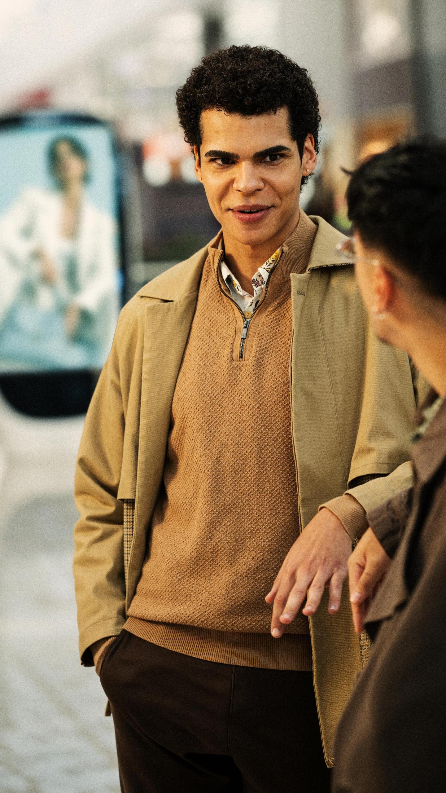 man stood talking in front of shopping centre advertising screen