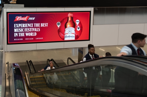 Budweiser advertises music festival partnerships on large overhead digital screen in LAX T4