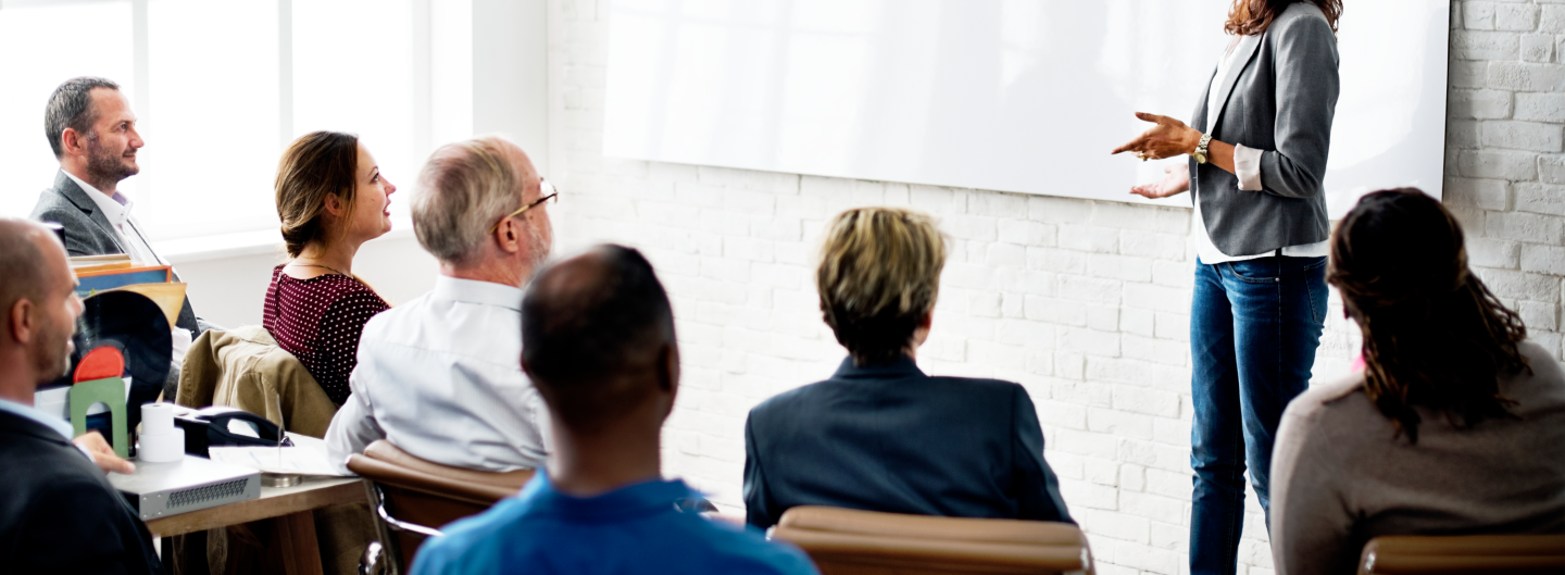 Professionals sit in a conference room for a financial seminar