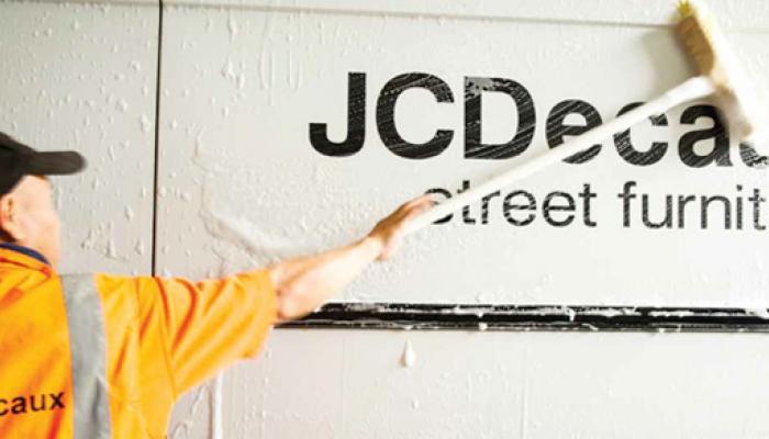 Ops cleaning a wall saying JCDecaux Street Furniture