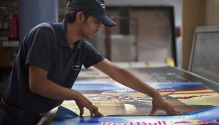 Technician smooths static ad poster in warehouse