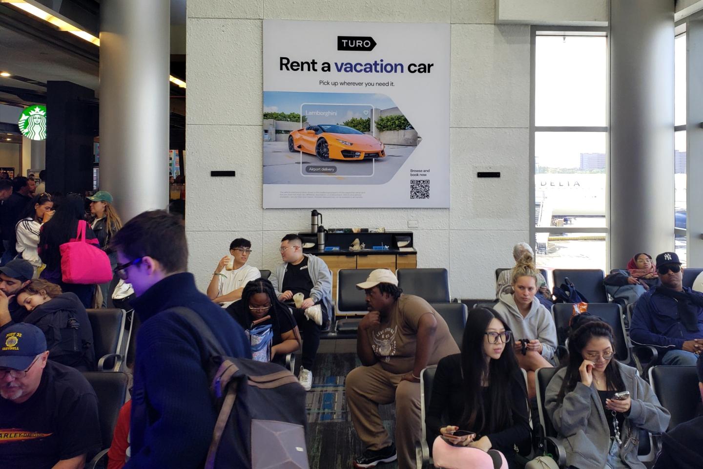Turo advertises their vacation car rentals in a busy gatehold area at Miami International Airport