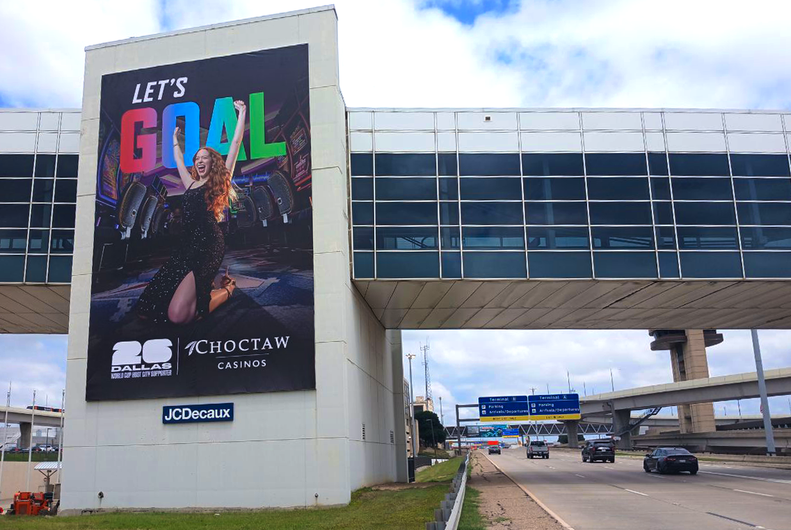 Choctaw advertises with FIFA World Cup creative at Dallas Fort Worth Intl Airport next to the roadway
