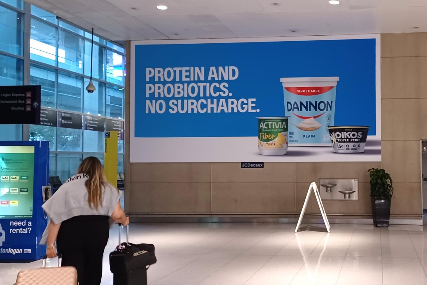 Danone advertises some of their food products on a large format static banner in the busy Boston Logan airport
